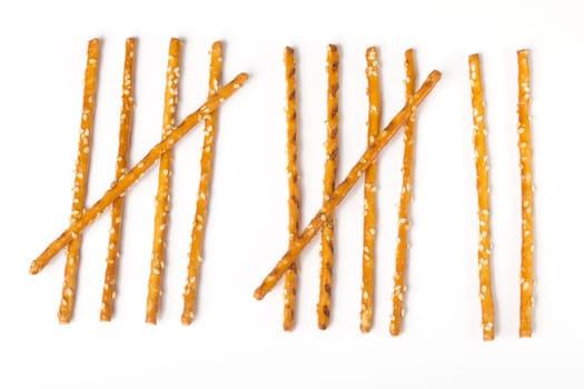 Tally list laid out of pretzel sticks on white background