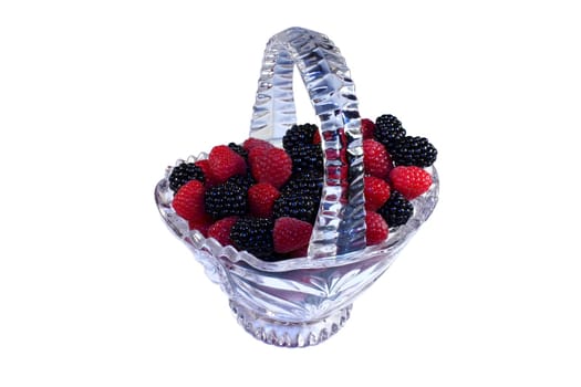 Glass basket full of fresh raspberries and blackberries