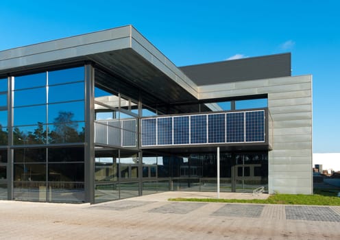entrance of a modern office building with solar panels for energy supply