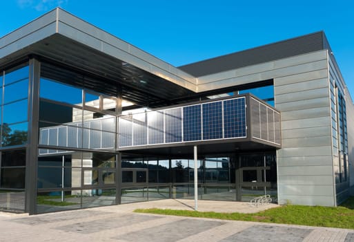 entrance of a modern office building with solar panels for energy supply
