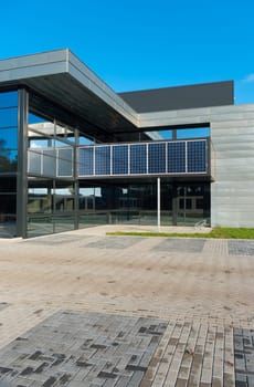 entrance of a modern office building with solar panels for energy supply