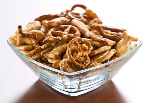 Salty snacks in square bowl close up