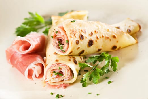 Pancakes filled with curd and prosciutto close up