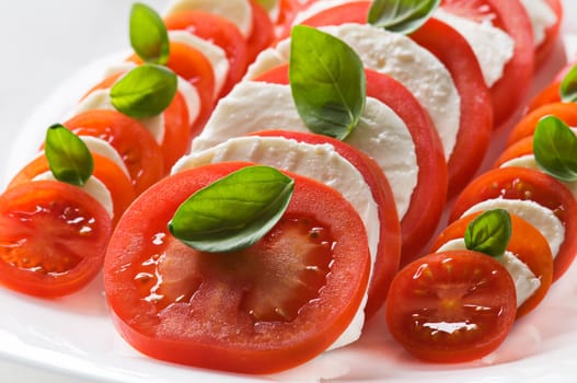 Sliced tomato and mozzarella with basil close up