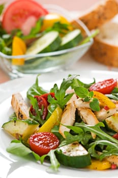 Chicken salad with rocket and vegetables close up