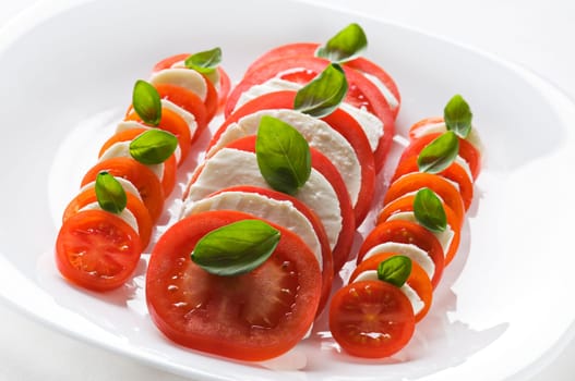 Sliced tomato and mozzarella with basil close up