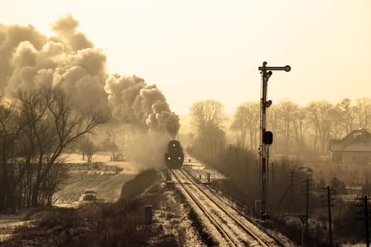 Vintage steam train starting from the station, wintertime