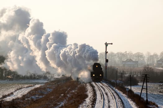 Vintage steam train starting from the station, wintertime