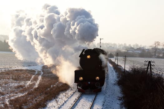 Vintage steam train starting from the station, wintertime
