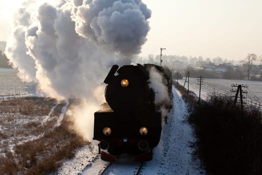 Vintage steam train starting from the station, wintertime
