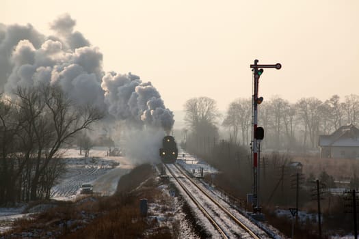Vintage steam train starting from the station, wintertime