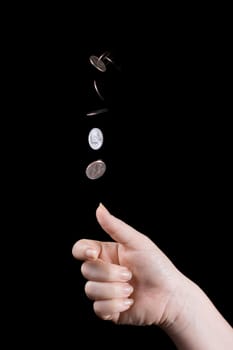 Multiple exposure image of hand flipping a coin on black background