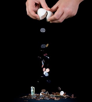 Money pouring out of the broken egg against black background