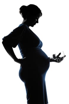 beautiful caucasian pregnant woman baby bottle in silhouette on studio isolated white background