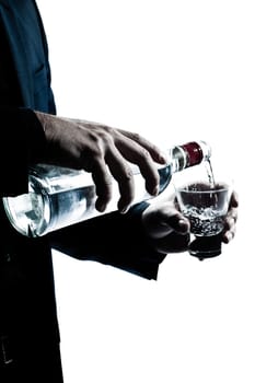 one caucasian man hands close up pouring white alcohol in a glass silhouette in studio isolated white background