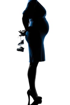 beautiful caucasian pregnant woman holding baby shoes in silhouette on studio isolated white background