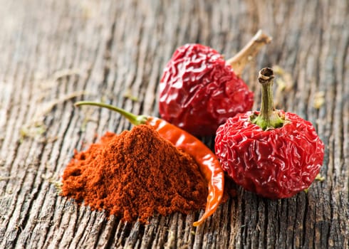 Two chili peppers with powder close up shoot