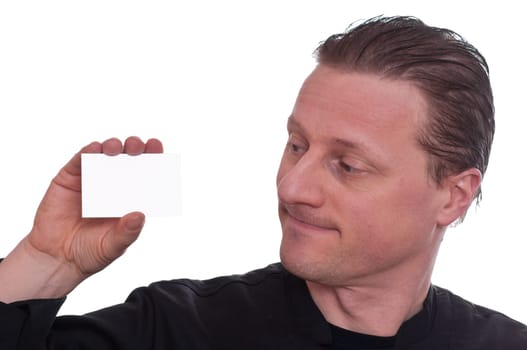 A man as a chef looks at a white business card in his hand