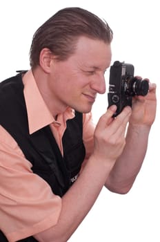 A male photographer looks through a camera and sets the distance
