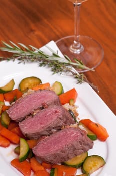 Saddle of lamb fillet with mustard and bread crust on glazed carrots and zucchini