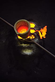Foundry - molten metal in crucible standing on moulds - leftover