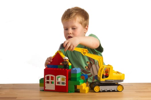 Boy builds a house out of building blocks