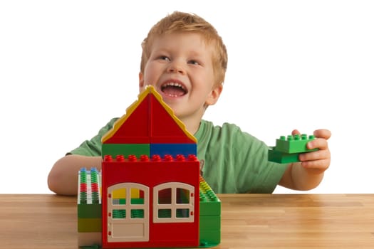 Boy builds a house out of building blocks