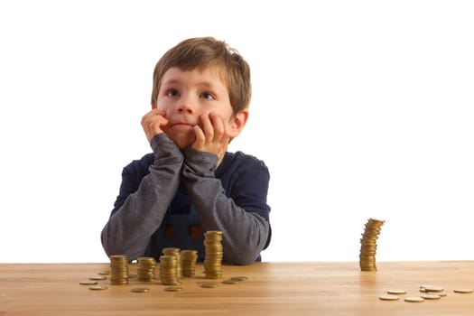 A boy sits in front of several stacks of money