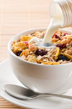 Fresh corn flakes, muesli and milk close up