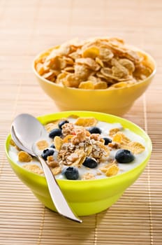 Corn flakes with blue berries and milk close up