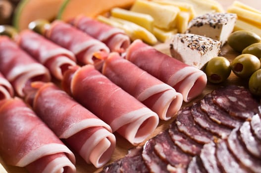 Fresh prosciutto with olives and cheese close up shoot
