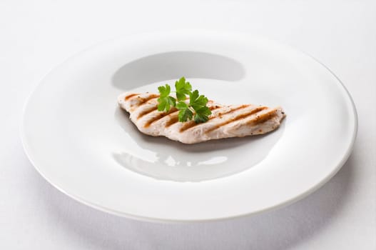 Grilled chicken steak on a plate close up