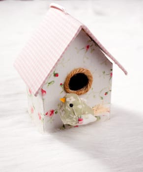 bird in a nest fabric house with round window in pastel colors