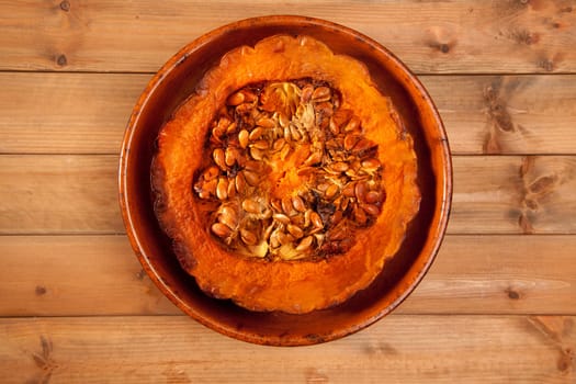 cutted half pumpkin roasted pumpkin on pottery clay dish