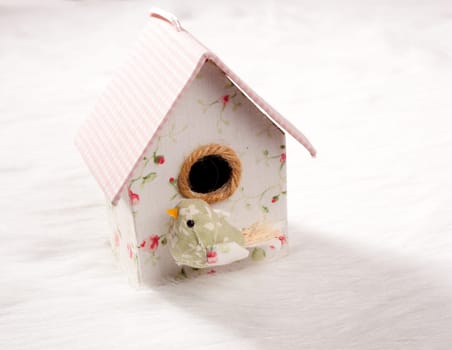 bird in a nest fabric house with round window in pastel colors