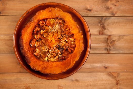 cutted half pumpkin roasted pumpkin on pottery clay dish