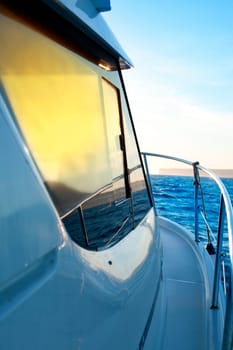 blue golden sunrise sailing on boat side with Mediterranean coastline in horizon