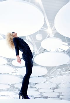 Blond futuristic vintage sexy woman in black on modern indoor full length
