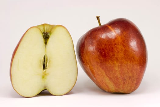 A ripe red apple and half apple. Isolated on a white background