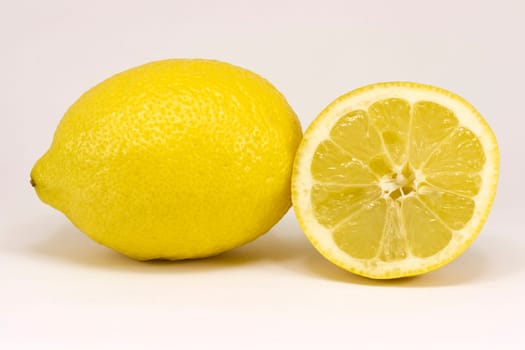 Two lemons, one cut in half and isolated blank