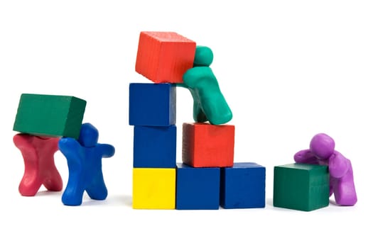 teamwork concept. plasticine people building wooden blocks