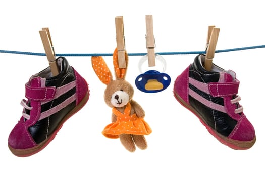Blue pacifier ,toy and baby shoes hanging on a cord. isolated on white background