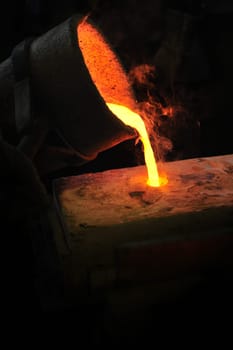 Foundry - molten metal poured from ladle into mould - lost wax casting