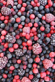 Close up of frozen mixed fruit - berries - red currant, cranberry, raspberry, blackberry, bilberry, blueberry, black currant