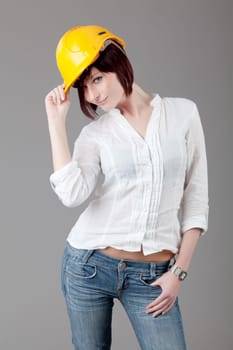 Portrait of confident female worker in yellow helmet. Engineer woman in yellow helmet