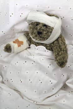 Injured teddy bear in bed