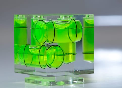 Three green spirit levels in plastic cube setting angle in any direction
