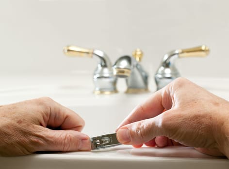 Finger nail clippings in palm of hand on bathroom sink