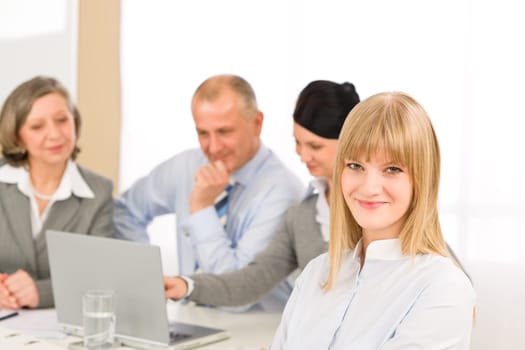 Businesswoman smiling at team meeting with colleagues