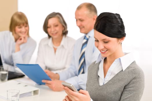 Young executive woman use phone during meeting with team colleagues